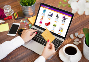 Woman shopping online on laptop and paying for purchased goods by credit card